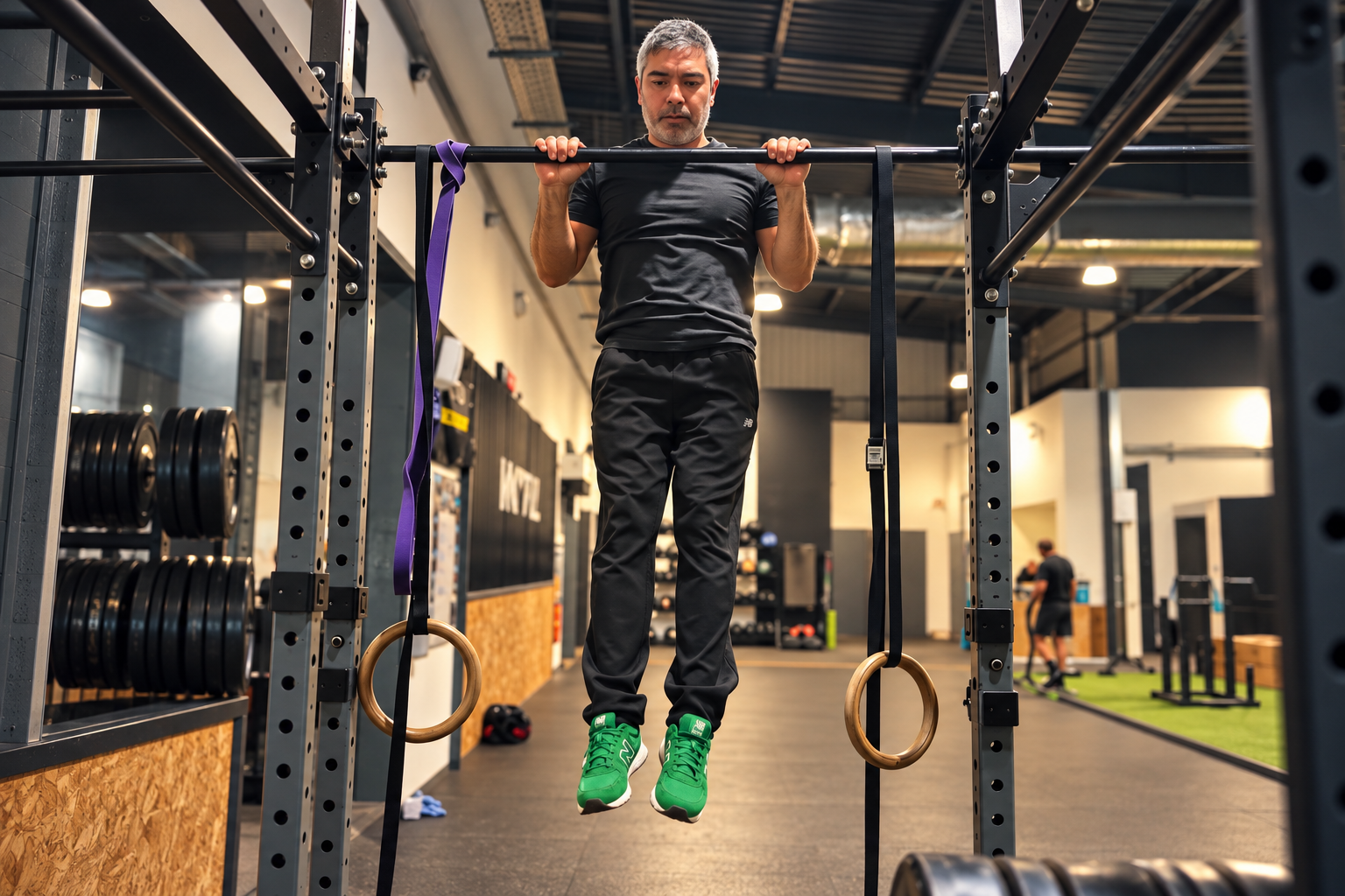 Eugene performing a pull-up on a gym rig above gymnastic rings