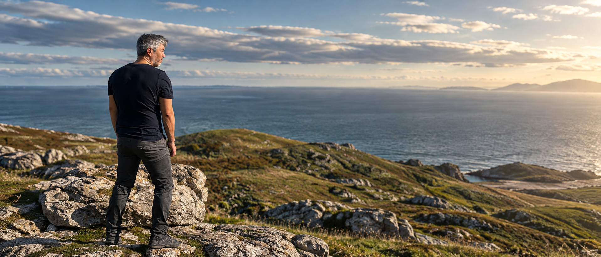 Eugene standing on a rocky coastal headland looking out to sea
